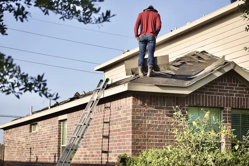 Professional roofer working on a residential roof in Coffeyville
